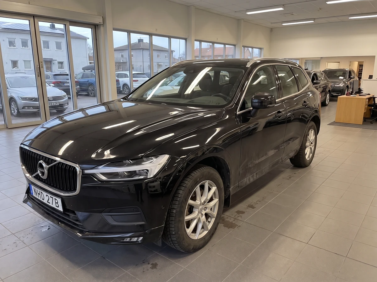 En svart Volvo XC60 fotad med mobil i en bilhall